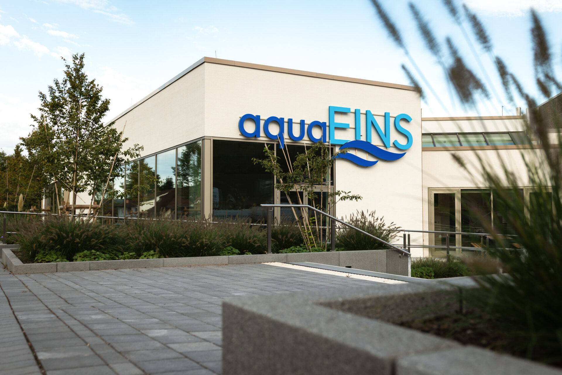 Außenansicht des Hallenbads aquaEINS mit Schriftzug am Einsiedlerbach in Hameln